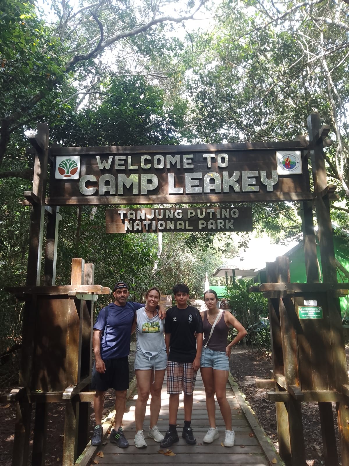 Family posing at the iconic Camp Leakey entrance gate deep in Tanjung Puting National Park.