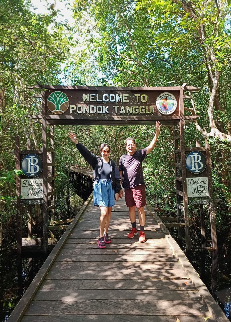 Guests waving happily at the Pondok Tanggui rehabilitation station welcome arch.