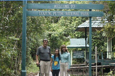 Our guests posing happily in front of the Tanjung Puting National Park entrance sign.