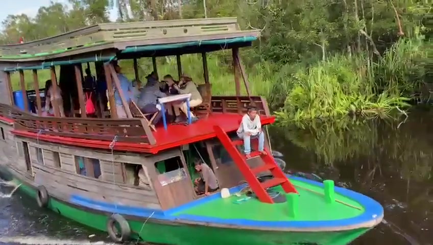 Relaxing on the deck of our klotok while cruising along the quiet river.